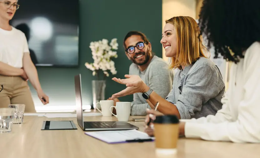 People in a meeting sitting down smiling and talking together.jpg